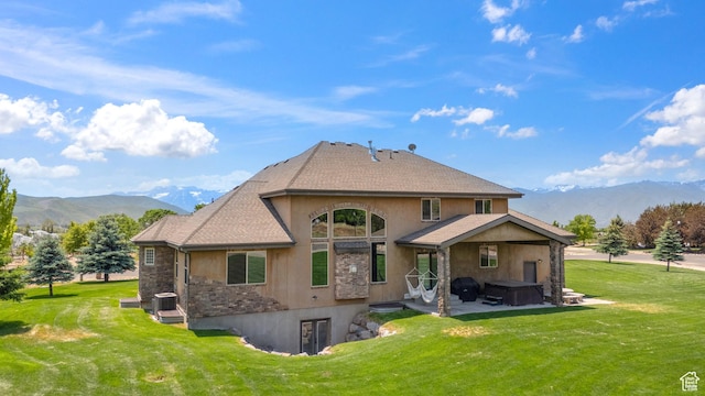 1865 S 3350 E, Heber City, UT 84032 - back of house featuring a hot tub, a mountain view, stucco siding, and a lawn