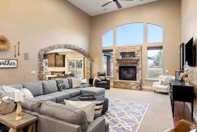1865 S 3350 E, Heber City, UT 84032 - living room featuring a high ceiling, a ceiling fan, a stone fireplace, and arched walkways