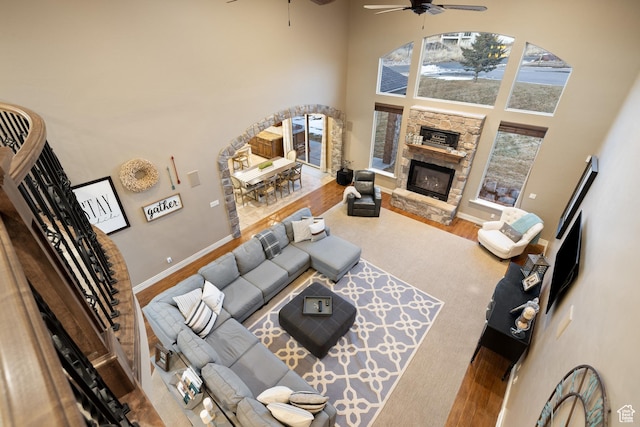 1865 S 3350 E, Heber City, UT 84032 - living room featuring a towering ceiling, a ceiling fan, a stone fireplace, and wood finished floors