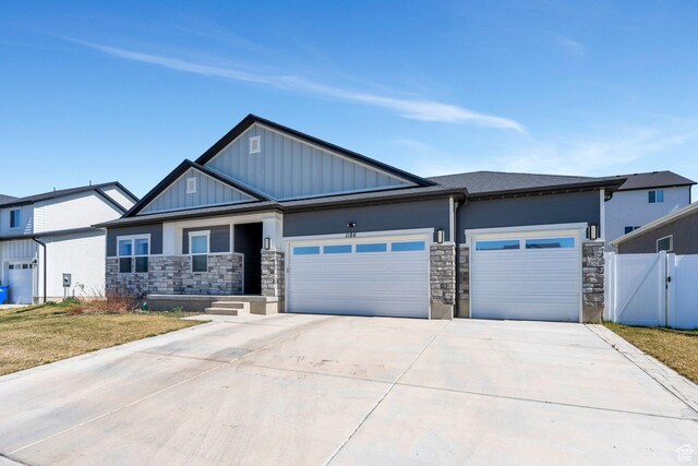 1186 N Buckboard Ln, Spanish Fork, UT 84660 - view of front facade featuring stone siding, a garage, board and batten siding, a gate, and driveway