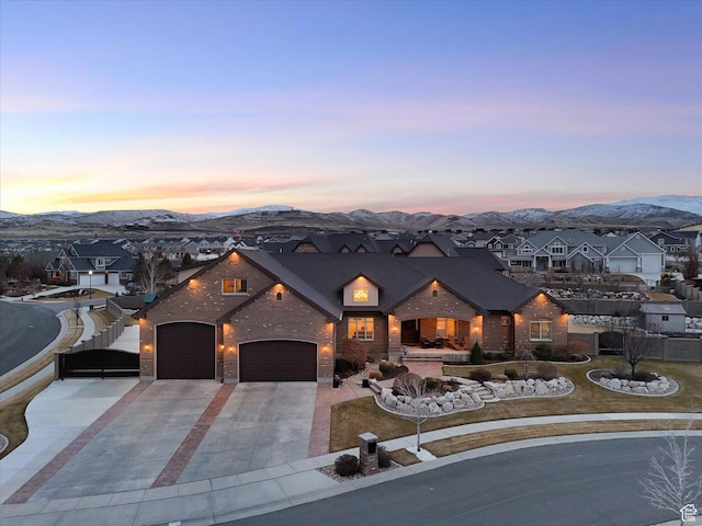 view of front of property with a residential view, a mountain view, driveway, and a garage