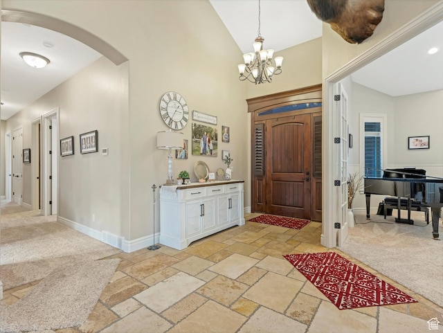 14738 S Currant Creek Cir W, Bluffdale, UT 84065 - foyer with arched walkways, stone tile floors, a chandelier, baseboards, and high vaulted ceiling