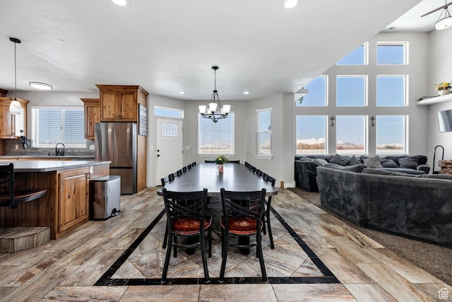 dining area with plenty of natural light, recessed lighting, and an inviting chandelier