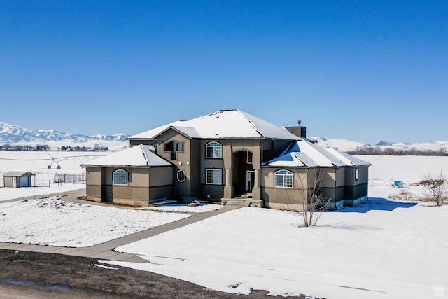 view of front facade with stucco siding and a mountain view