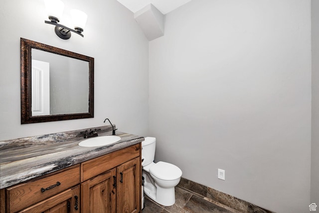 half bath with vanity, toilet, and baseboards