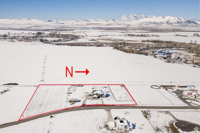 snowy aerial view featuring a mountain view