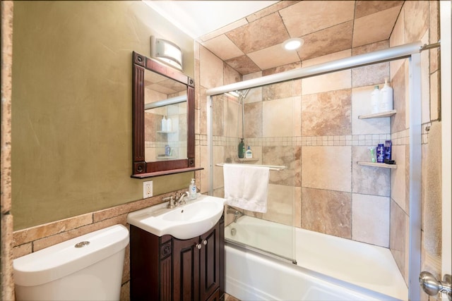 full bathroom featuring toilet, vanity, and bath / shower combo with glass door