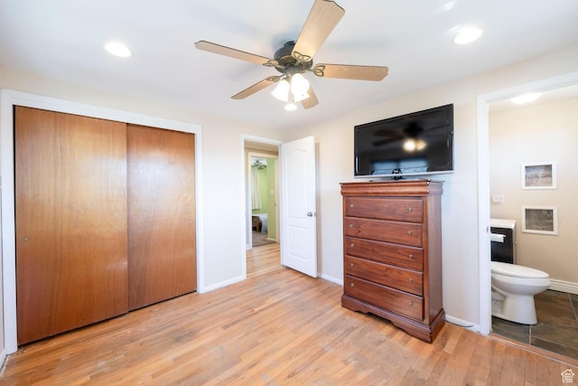 bedroom featuring baseboards, ensuite bath, recessed lighting, a closet, and light wood-type flooring