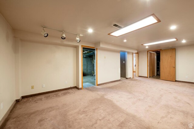 finished basement featuring visible vents, baseboards, recessed lighting, rail lighting, and light carpet