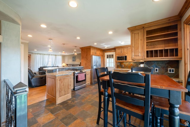 kitchen with a peninsula, recessed lighting, decorative backsplash, appliances with stainless steel finishes, and crown molding