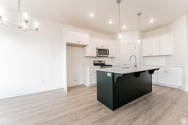 642 W 4500 S Unit 322, Mapleton, UT 84664 - kitchen with stainless steel appliances, light wood-style floors, white cabinets, a kitchen bar, and recessed lighting