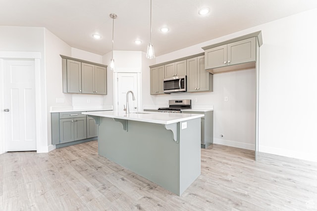 624 W 4500 S Unit 325, Mapleton, UT 84664 - kitchen with gray cabinets, stainless steel appliances, a kitchen breakfast bar, light wood-style floors, and recessed lighting