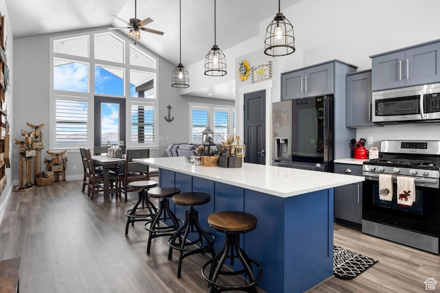 3278 S Serviceberry Dr Unit 18, Garden City, UT 84028 - kitchen with appliances with stainless steel finishes, a breakfast bar area, a kitchen island, high vaulted ceiling, and ceiling fan