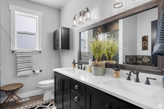 3278 S Serviceberry Dr Unit 18, Garden City, UT 84028 - bathroom featuring baseboards, toilet, double vanity, and wood finished floors