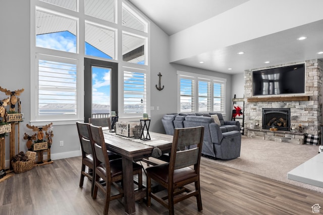 3278 S Serviceberry Dr Unit 18, Garden City, UT 84028 - dining room featuring a stone fireplace, wood finished floors, a high ceiling, baseboards, and recessed lighting