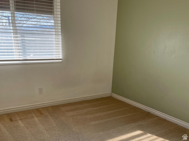 unfurnished room featuring carpet flooring and baseboards
