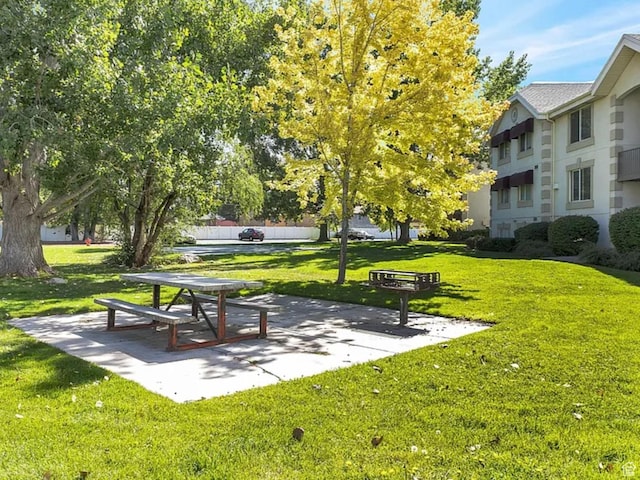 surrounding community with a patio area and a lawn