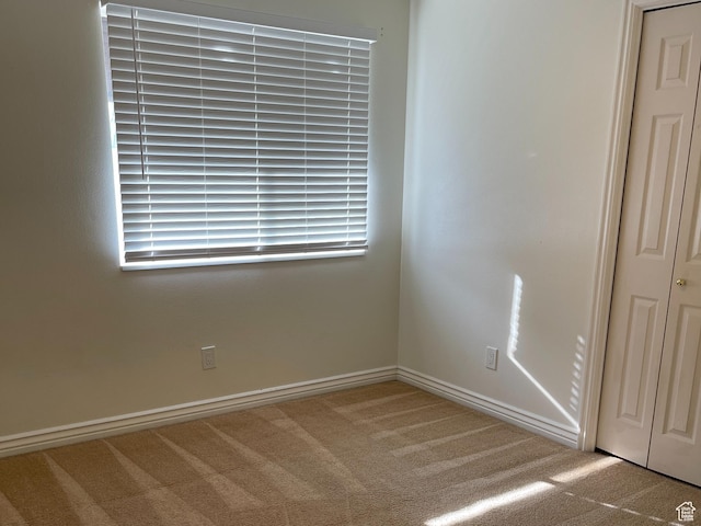 unfurnished room with baseboards and carpet floors