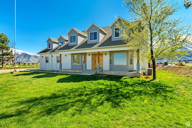cape cod house featuring a porch, a front yard, a shingled roof, cooling unit, and brick siding