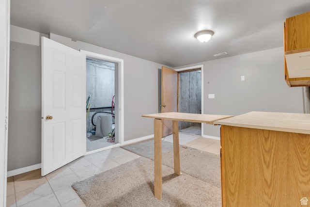 unfurnished dining area featuring baseboards and light tile patterned floors