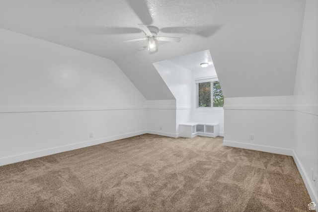 bonus room with ceiling fan, carpet floors, a textured ceiling, and vaulted ceiling