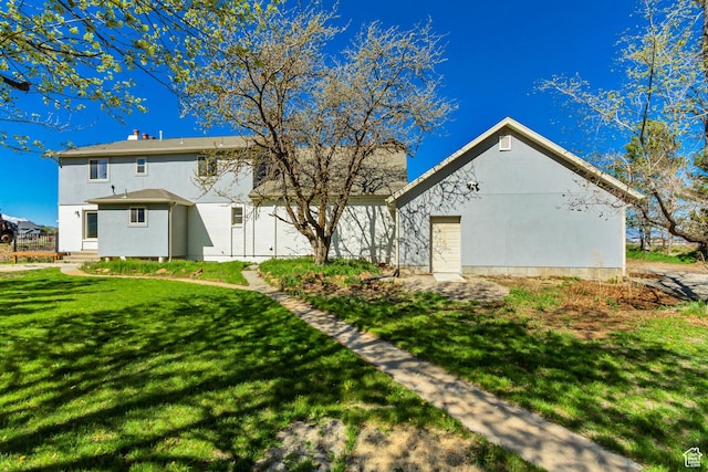 back of property featuring a yard and stucco siding
