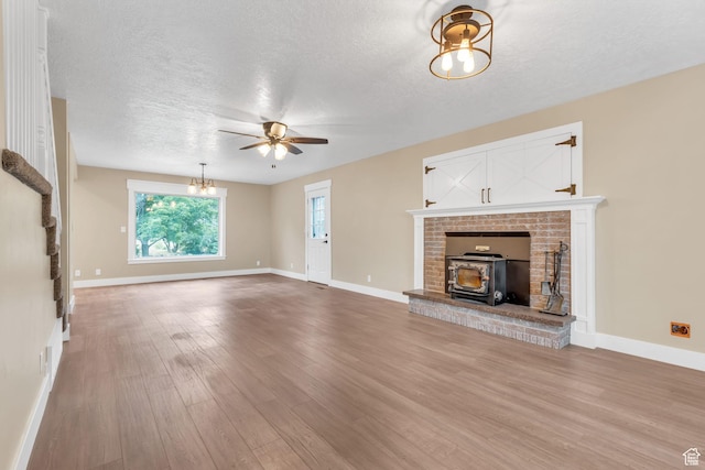 unfurnished living room featuring a textured ceiling, ceiling fan, wood finished floors, and baseboards