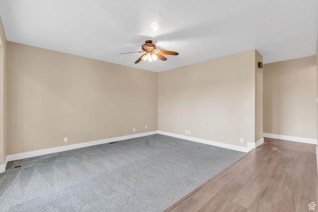 spare room featuring baseboards, wood finished floors, and ceiling fan
