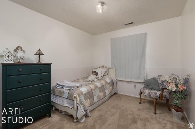 bedroom featuring visible vents, baseboards, light colored carpet, and a textured ceiling