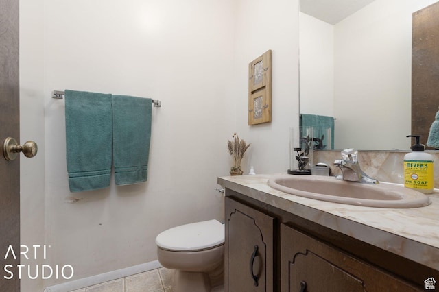 bathroom with tile patterned flooring, toilet, vanity, and baseboards