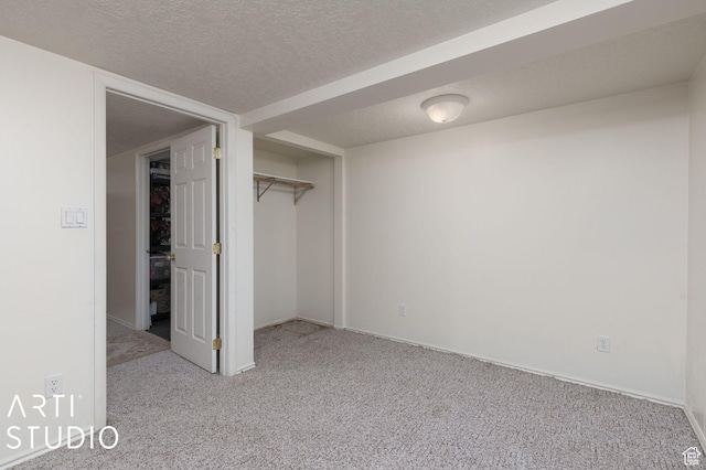 unfurnished bedroom featuring a closet, a textured ceiling, and carpet