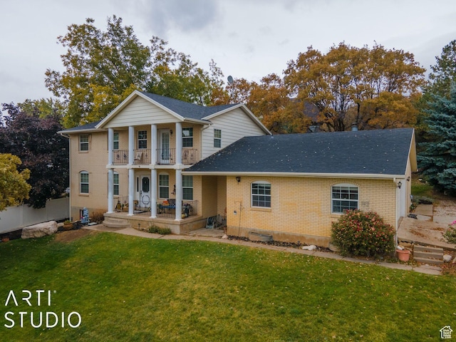 view of front of home featuring brick siding, a front lawn, fence, covered porch, and a balcony