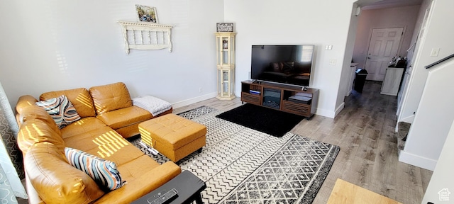 living area with light wood-type flooring and baseboards