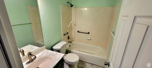 bathroom with shower / bathing tub combination, toilet, wood finished floors, and vanity