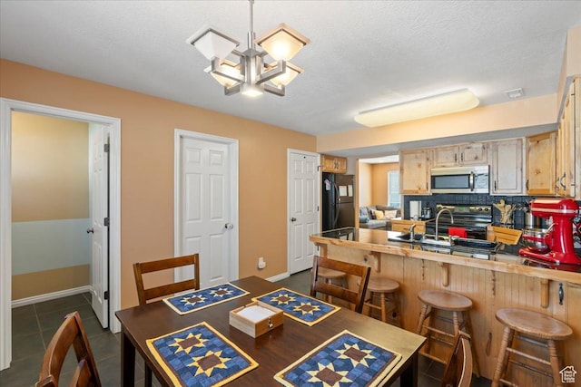 1322 E 6175 S, South Ogden, UT 84405 - dining space featuring dark tile patterned floors, baseboards, a textured ceiling, and an inviting chandelier