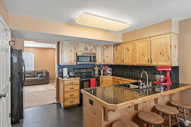 1322 E 6175 S, South Ogden, UT 84405 - kitchen with a kitchen bar, black appliances, light brown cabinets, a peninsula, and decorative backsplash