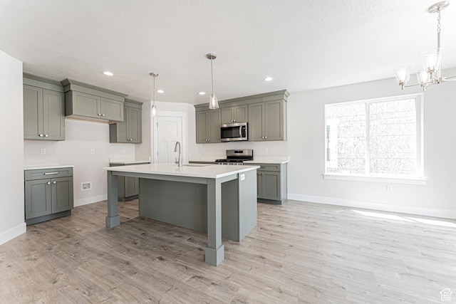 1015 N 3685 W Unit 247, Lehi, UT 84043 - kitchen featuring appliances with stainless steel finishes, light wood finished floors, light countertops, a chandelier, and recessed lighting