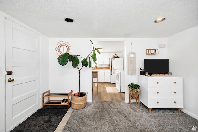 interior space featuring a textured ceiling and light carpet