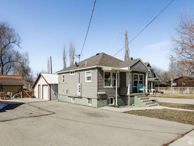 view of front of property with a garage, an outdoor structure, and fence