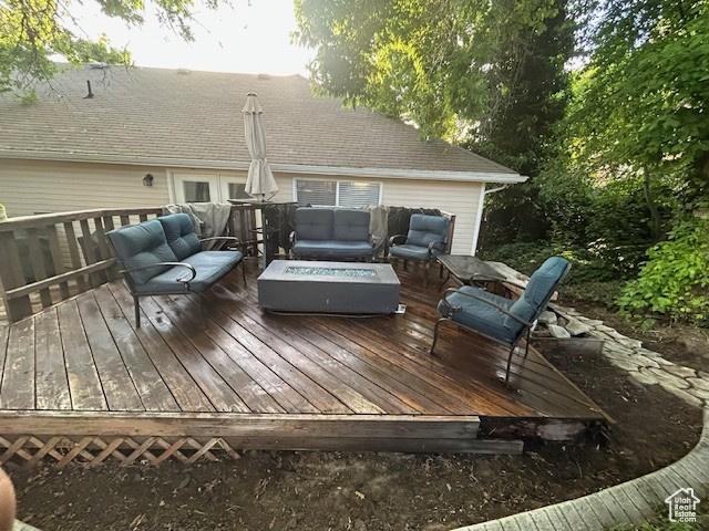 wooden terrace with an outdoor living space with a fire pit