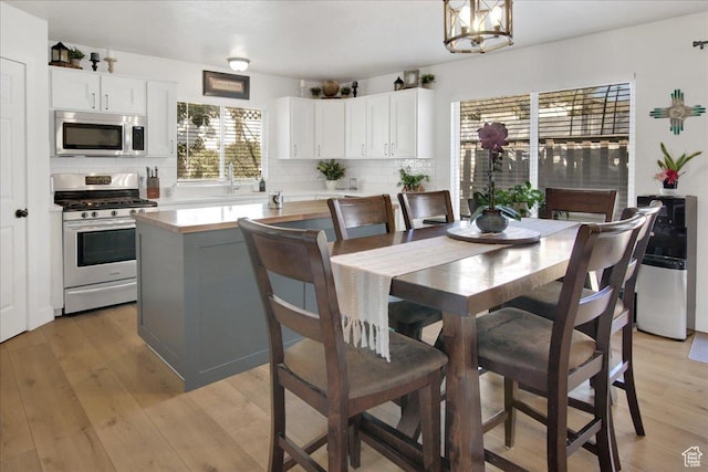 dining area featuring light wood-type flooring and an inviting chandelier