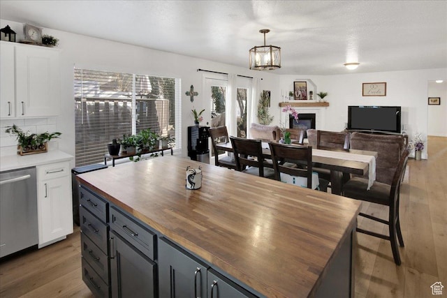 dining room with a glass covered fireplace and light wood-type flooring