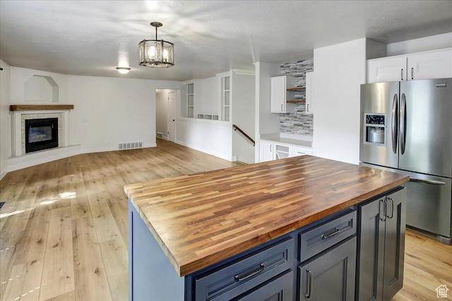 5772 Oakwood Dr, South Ogden, UT 84405 - kitchen featuring stainless steel fridge with ice dispenser, butcher block counters, light wood-style flooring, white cabinetry, and a textured ceiling