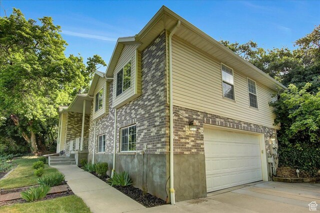 5772 Oakwood Dr, South Ogden, UT 84405 - view of side of property featuring an attached garage and driveway