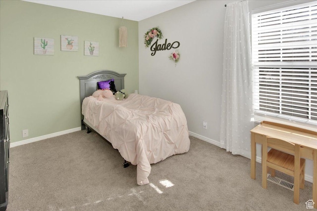 carpeted bedroom featuring multiple windows and baseboards