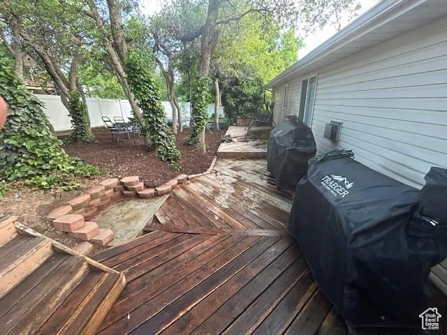 wooden terrace featuring area for grilling and fence