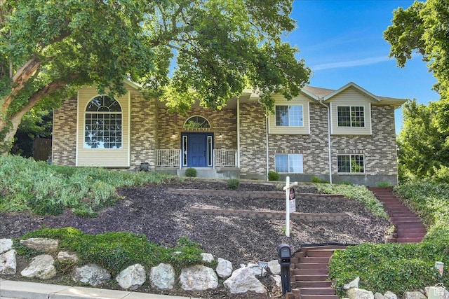 5772 Oakwood Dr, South Ogden, UT 84405 - view of front facade featuring stairway, covered porch, and brick siding