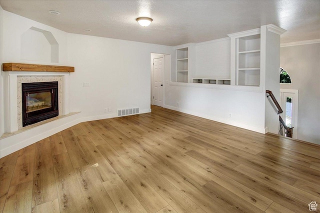 5772 Oakwood Dr, South Ogden, UT 84405 - unfurnished living room with wood finished floors, a premium fireplace, built in shelves, crown molding, and a textured ceiling