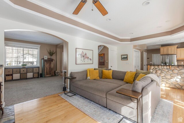 161 W Swiss Farm Way Unit 9, Midway, UT 84049 - living area featuring ornamental molding, light wood-style floors, arched walkways, a raised ceiling, and a ceiling fan