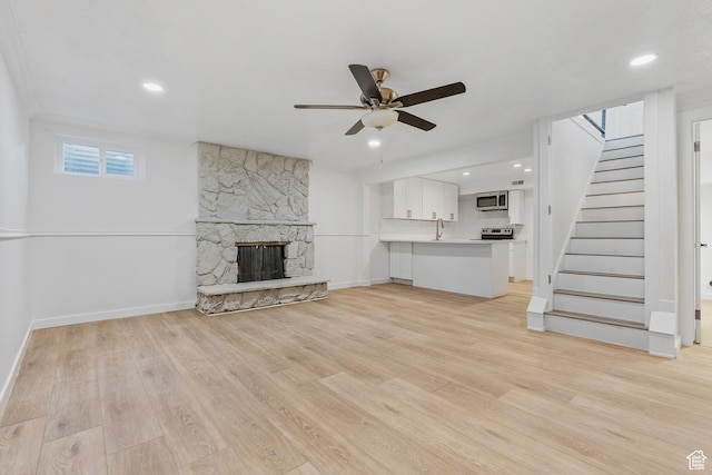 4375 S 2700 E, Holladay, UT 84124 - unfurnished living room with a ceiling fan, a sink, a fireplace, light wood finished floors, and stairs